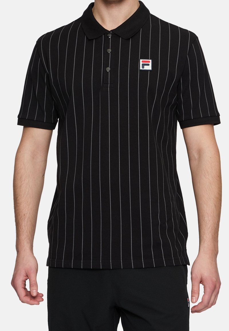 Polo noir avec des rayures verticales grises, un col et trois boutons. Présente un petit logo rouge et bleu sur la poitrine gauche.