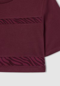 Burgundowa bluzka crop top z krótkimi rękawami, gładką teksturą i kontrastowym panelem z siatki w ciemnoróżowy wzór w zebry.