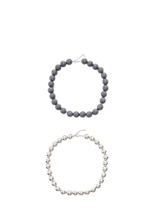 Two necklaces with large round beads, one dark gray and one shiny silver, each with a small chain clasp on a white background.