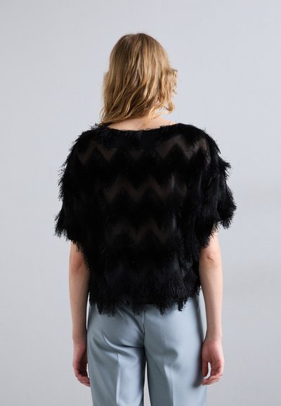 Must värviga lühikeste varrukatega pluus, millel on tekstuuriga frantsi muster ja chevroni disain; kantud helesiniste püksidega; läbipaistev materjal.