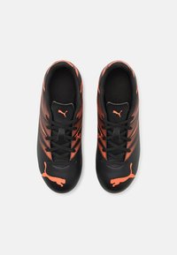 Pantofi de fotbal negri cu accente portocalii, având un superior din plasă, design cu șireturi, țesătură texturată și un logo Puma proeminent pe lateral.