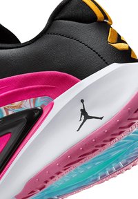 Scarpa da corsa nera e rosa con tomaia testurizzata, intersuola marmorizzata e suola trasparente in gomma con un accento di logo prominente.