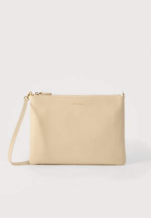 Pochette à bracelet en cuir beige texturé avec fermeture éclair dorée et bandoulière amovible, nom de la marque embossé au centre, le tout sur un fond uni.