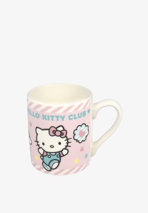 Weiße Keramiktasse vor rosa Hintergrund, mit blauem Text "HELLO KITTY CLUB" und der Hello Kitty Figur, die blaue Latzhose und eine rosa Schleife trägt.