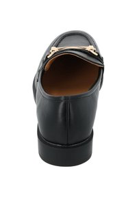 Scarpa in pelle nera con punta arrotondata, caratterizzata da un accento in metallo dorato e una suola bassa e testurizzata. Interno foderato con materiale beige.