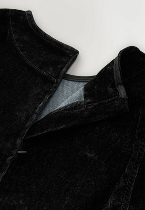 Crna kadrova jakna s ovratnikom i kopčanjem na gumbi. Obložena svijetloplavim materijalom, s teksturiranom površinom i prilagođenim oblikom.