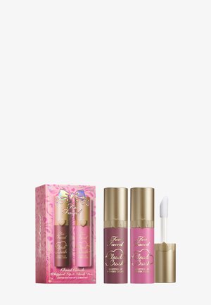 Twee tubes met geklopte lip- en wangkleur in roze en mauve, met gouden doppen, verpakt in een roze doos met kleurrijke strikafbeeldingen.