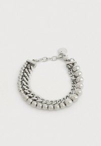 Bracciale argento con due stili di catena e accenti di perline rotonde, fissato con un gancio regolabile e un piccolo charm con marchio.