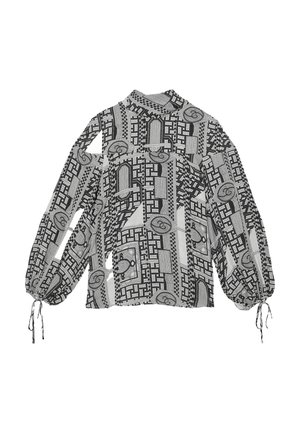 Blouse met lange mouwen in zwart-witte stof; met geometrische patronen, volumineuze mouwen en aantrekkoordjes bij de polsen.