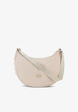 Beige Umhängetasche mit runder Form, aus Stoffmaterial, verstellbarem Gurt und einem kleinen Logo-Anhänger auf der Vorderseite.