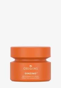 Contenitore circolare arancione della crema occhi illuminante Origins Ginzing. Finitura opaca liscia, etichetta bianca con dettagli del prodotto.