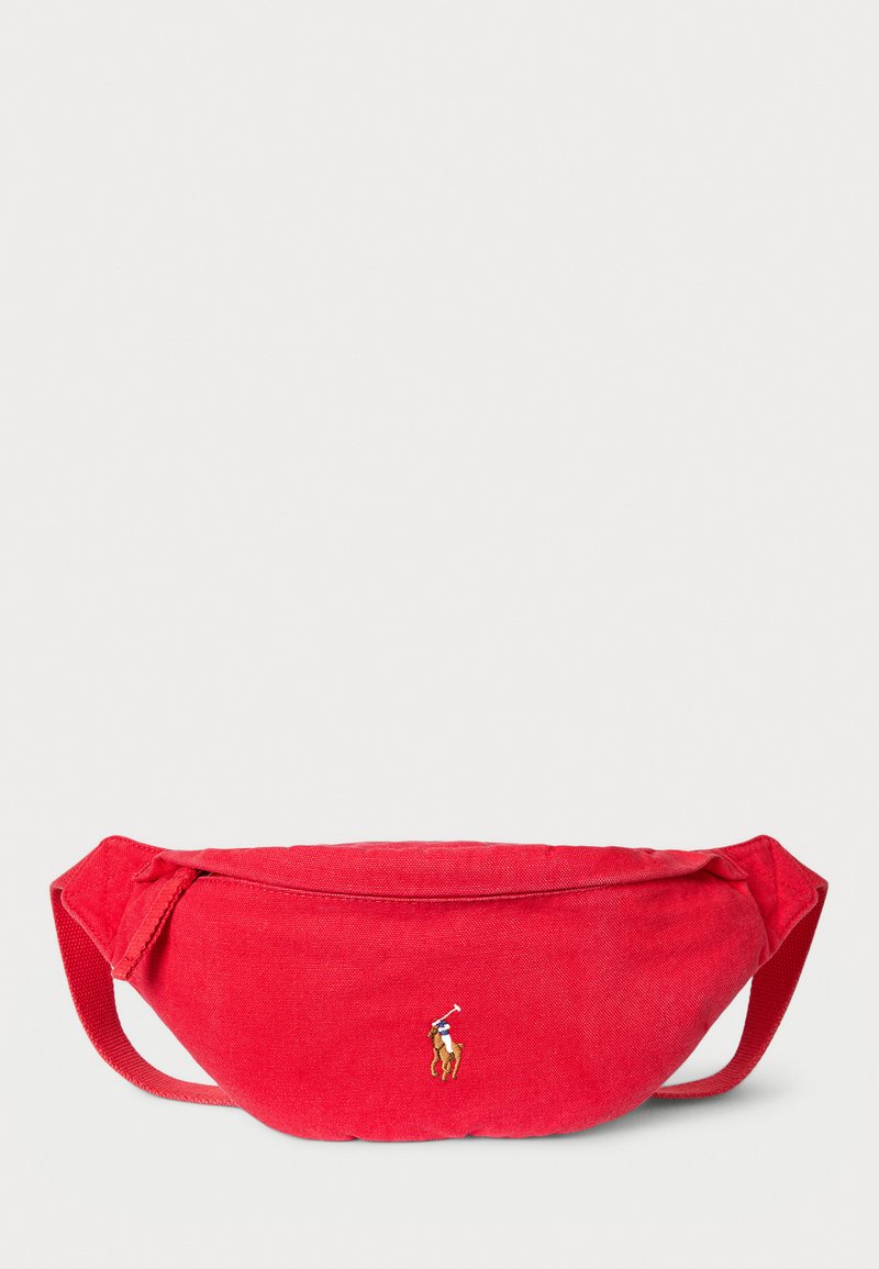 Red fabric fanny pack with a smooth texture; features a small embroidered logo. Design incorporates adjustable straps for secure wear.