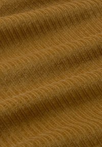 Close-up of soft, ribbed fabric with a warm brown color and textured, parallel ridges creating gentle folds.