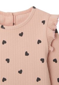 Geripptes, pinkes Langarmshirt mit schwarzen Herzmustern und einem gerafften Schulterdetail, mit einem Knopfverschluss am Rücken.