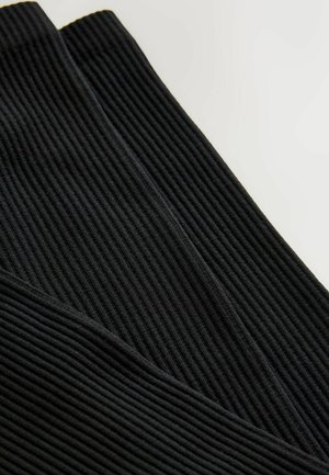 Mustat ribbed-legginssit, joissa on teksturoitu pinta ja tiukka muotoilu, korostaen pystysuoria raitoja kankaan läpi.