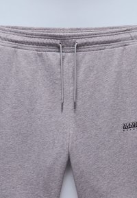 Gray sweatpants with a smooth texture, featuring an elastic waistband with drawstrings and a small logo on the lower left side.