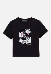 Μαύρο βαμβακερό t-shirt με κεντρικό γραφικό στοιχείο από λευκά και κόκκινα αφηρημένα φύλλα με υφή και λογότυπο στο κάτω μέρος.