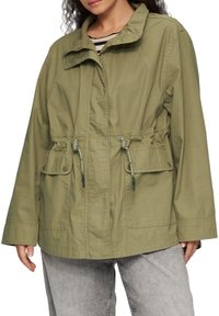 Veste vert olive avec un col, taille élastique, deux poches avant et cordons de serrage ajustables. Fabriquée en tissu léger avec une finition mate.
