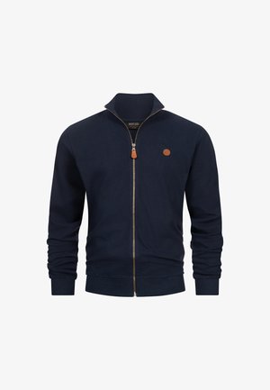 Námořnická modrá mikina na zip z texturované látky s vysokým límcem, žebrovanými manžetami a spodním lemem. Obsahuje malou hnědou nášivku s logem a kožený taháček na zip.