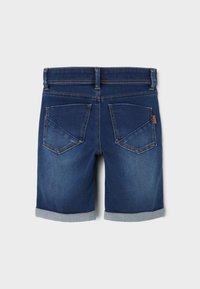 Σορτς από τζιν σε σκούρο μπλε χρώμα με ρολέ λαιμούς, διαθέτει δύο πίσω τσέπες και μια μικρή καφέ δερμάτινη ετικέτα στη μέση.