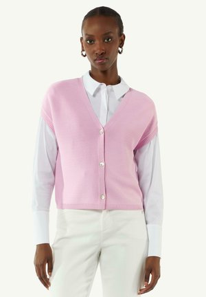 Pink knitted cardigan with a V-neck and five buttons, worn over a white collared shirt. Features ribbed details and short sleeves.
