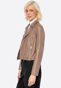 Bruine leren motorjack met een cropped ontwerp, notch revers en ritssluitingen. Heeft een gladde textuur en zilveren hardware accenten.