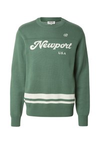 Pull-over vert avec l'inscription blanche « Newport U.S.A. », poignets et ourlet côtelés, et deux bandes horizontales blanches en bas.