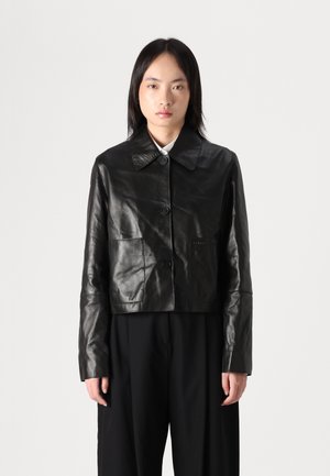 Black leather cropped jacket with a pointed collar, front buttons, and a single pocket on the left side. Smooth texture, tailored design.
