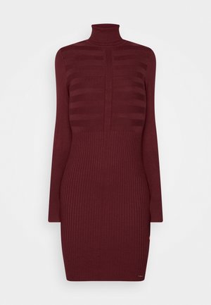 Robe en maille côtelée bordeaux avec manches longues et col roulé haut, avec des rayures horizontales sur la partie supérieure de la poitrine et une texture uni en dessous.