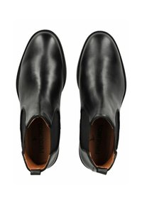 Bottines en cuir noir avec des panneaux elastiques sur les côtés, bout arrondi et doublure intérieure beige. Texture lisse avec un minimum de détails de couture.