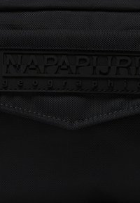 Borsa in nylon nera con una superficie testurizzata, logo in rilievo nero e accentuazione triangolare. Design elegante con dettagli minimi.