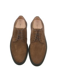 Braune Wildleder Schnürschuhe mit glatter Textur, kontrastierender schwarzer Gummisohle und gestickten Details entlang der Kanten.