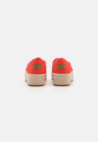Røde lerrets espadrillesko med frynsete kanter, flettede jute såler og brune merker på hælen. Enkel design med en strukturert overflate.