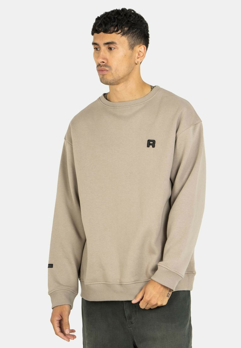 Beiger Sweatshirt mit Rundhalsausschnitt, gerippten Bündchen und einem kleinen schwarzen Logo auf der Brust. Weicher, strukturierter Stoff mit einer lockeren Passform.