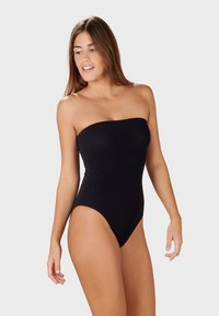 Mustat olkaimettomat uimapuvut, joissa on sileä pinta, korkeat lahkeet ja tiukka muotoilu, joissa on vähäiset saumat ja yksivärinen väri.