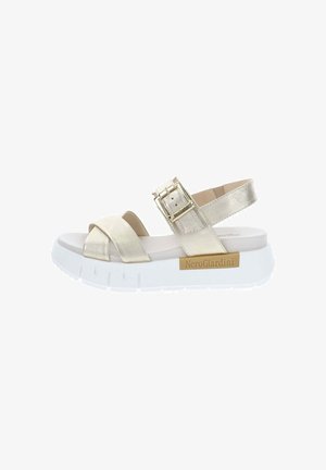 Sandalia de plataforma con tiras anchas metálicas doradas, hebilla ajustable, suela blanca gruesa y etiqueta de la marca NeroGiardini en el lateral.