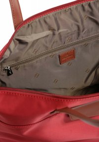 Borsa tote rossa con un'esterno liscio, dettagli in pelle, un ampio interno beige e una tasca con zip per un sicuro stoccaggio.