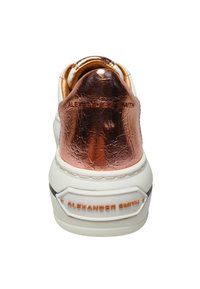 Sneaker bianca con un tallone in pelle lucida color oro rosa, con branding in rilievo e suola texturizzata. Design minimalista con linee pulite.