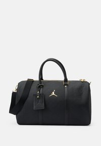 Mustat duffel-laukku, jossa on kohokuvioitu kuvio, kultaiset yksityiskohdat, yläkahvat ja säädettävä olkahihna. Varustettu logotagin ja vetoketjukiinnityksen kanssa.