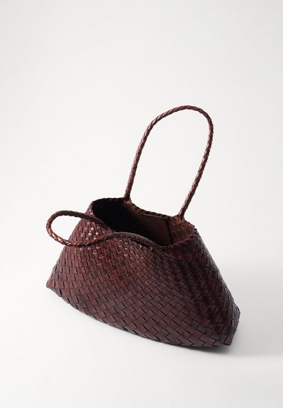 Υφασμένη καφέ δερμάτινη τσάντα με δύο πλεξούδες χερούλια, τριγωνικό σχήμα και υφή στην επιφάνεια. Το εσωτερικό δείχνει μια ετικέτα.