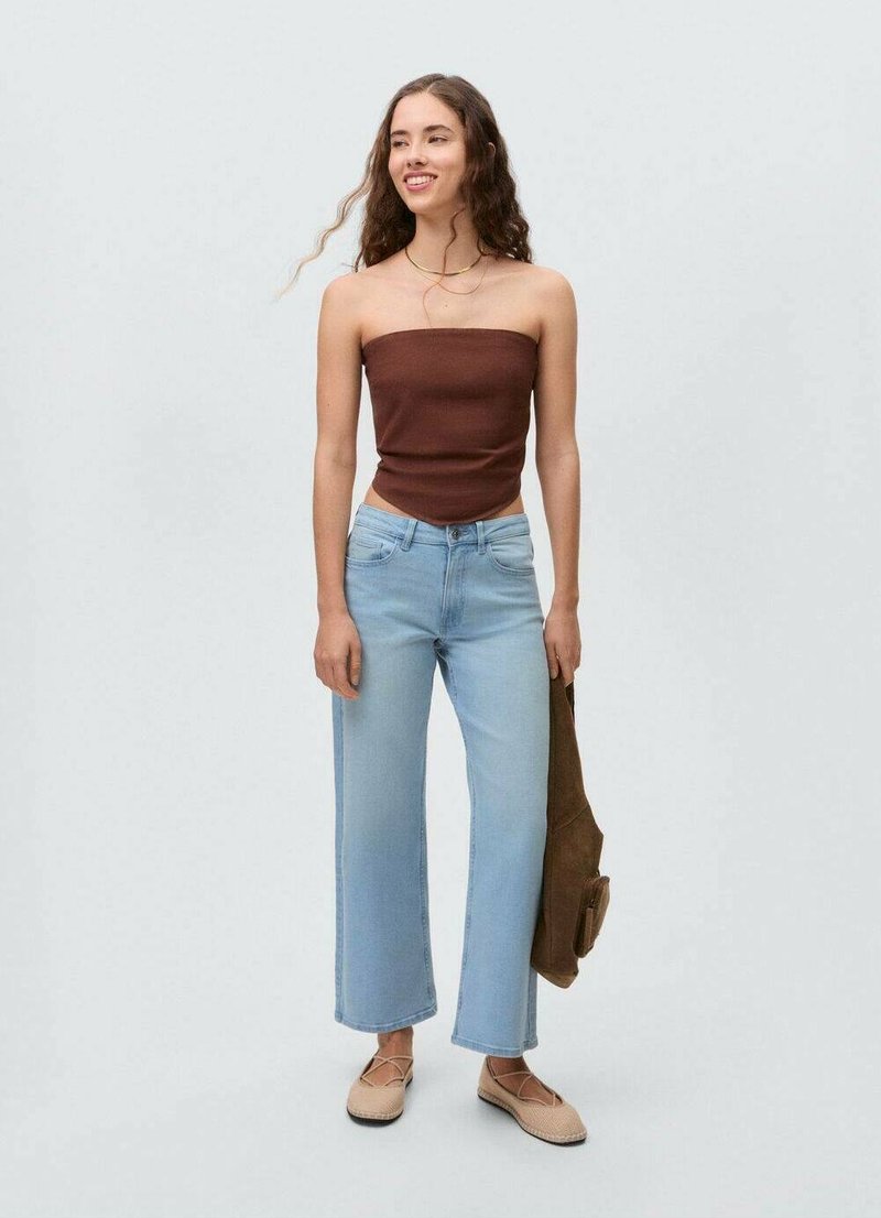 Braunes trägerloses Oberteil mit hellblauen weit geschnittenen Jeans, beigen Ballerinas und einer braunen Tasche. Glatte Textur, lässiges Design.