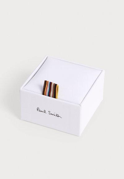 Boîte blanche de la marque Paul Smith avec une boucle en tissu rayée multicolore sur le dessus sur un fond uni.