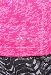 Růžová látka DRI-FIT s texturední, abstraktní vzor. Černý a šedý vlnitý design na spodní části. Viditelné švy.