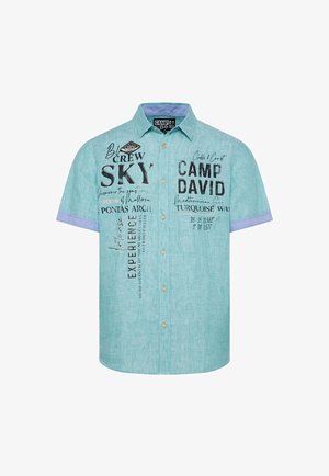 Košile s krátkým rukávem z světle tyrkysové tkaniny, s černým potiskem a akcenty, kontrastním modrým límcem a légou.