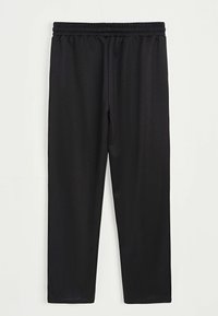 Pantalons noirs à taille élastique droit suspendus contre un fond blanc sans motifs ni logos visibles.