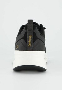 Černá sportovní bota s kontrastní bílou podrážkou, texturovaným svrškem a poutkem na zadní straně se zlatým logem.