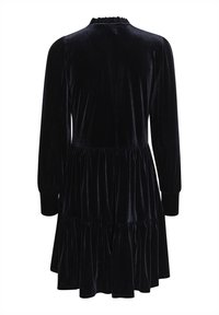 Robe longue en velours noir à manches longues avec jupe à volants, poignets ajustés et col froncé, vue de dos.