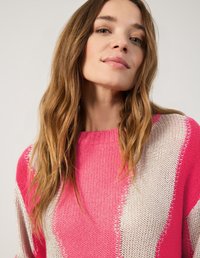 Gestrickter Pullover mit einem auffälligen design in rosa und weißen diagonalen Streifen. Rundhalsausschnitt, lange Ärmel und strukturierter Stoff.