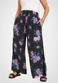 Svart blommig vida byxor med smockad midja, prydda med rosa och lila blommor, samt fickor på båda sidor. Mjuk tygkänsla.