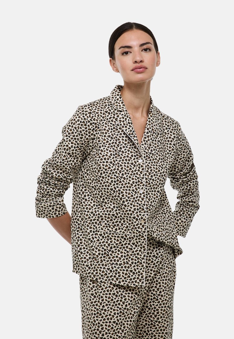 Ensemble pyjama imprimé léopard en beige et marron, comprenant une chemise à boutons avec col, manches longues et poche plaquée. Texture de tissu douce.